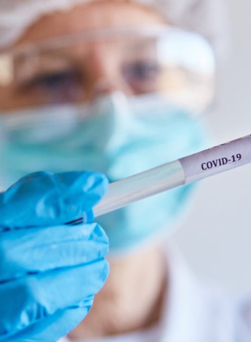 A nurse placing a sample from a COVID-19 test into a tube